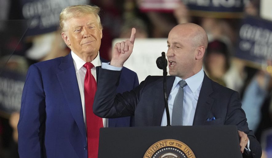 President Donald Trump listens as White House deputy chief of staff for policy Stephen Miller speaks on his first 100 days at Macomb County Community College Sports Expo Center, Tuesday, April 29, 2025, in Warren, Mich. (AP Photo/Paul Sancya)