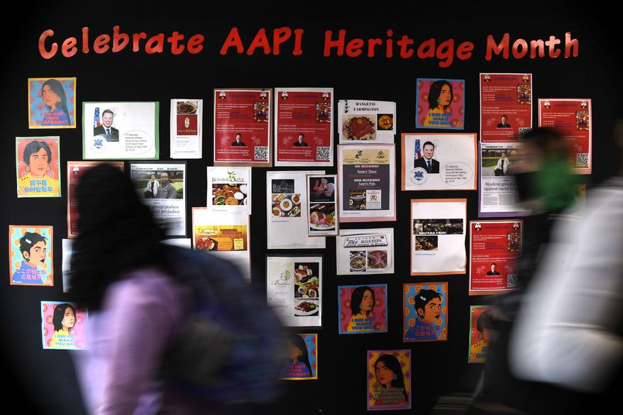FILE - Students walk past a display for Asian Pacific American Heritage Month at Farmington High School in Farmington, Conn., May 10, 2021. (AP Photo/Jessica Hill, File)