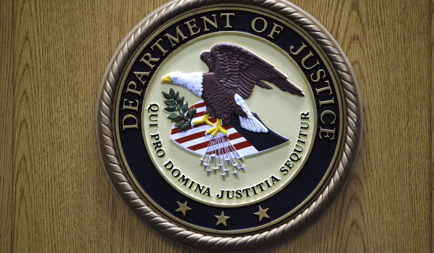 FILE - The Department of Justice logo is shown on a podium during a news conference, Sept. 30, 2010, in Philadelphia. (AP Photo/Matt Slocum, File)