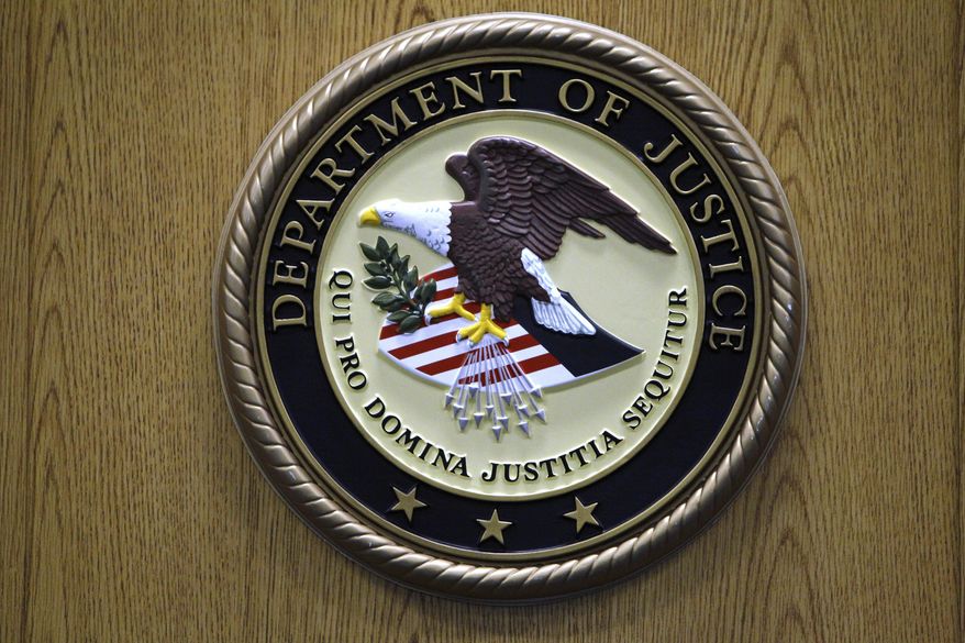 FILE - The Department of Justice logo is shown on a podium during a news conference, Sept. 30, 2010, in Philadelphia. (AP Photo/Matt Slocum, File)