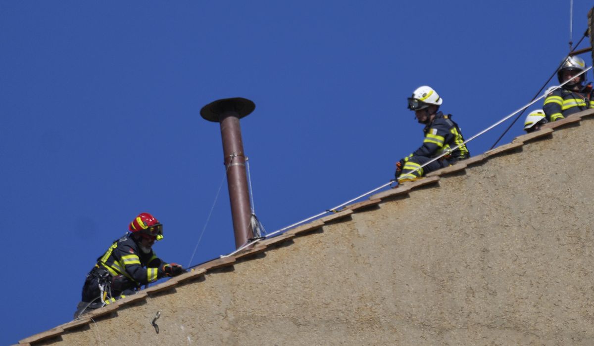NextImg:Vatican firefighters install a chimney on the roof of the Sistine Chapel for the papal election