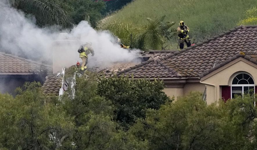 Firefighters work at the site of a plane crash in the Wood Ranch section of Simi Valley, Calif., on Saturday, May 3, 2025. (AP Photo/Mark J. Terrill)