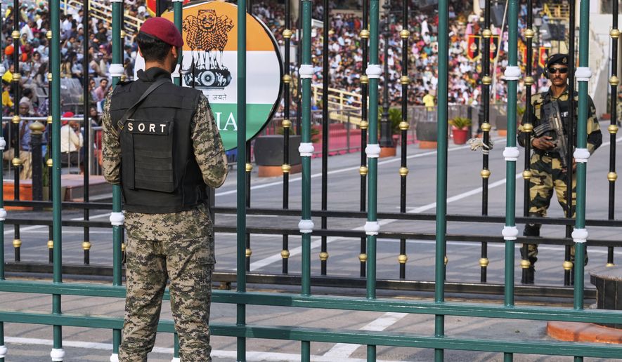 Pakistan's paramilitary soldier, left, and Indian Border Security Forces soldier, right, stand guard on their sides, during a daily closing ceremony at the Wagah, a joint post on the Pakistan and India border, near Lahore, Pakistan, Saturday, May 3, 2025. (AP Photo/K.M. Chaudary)