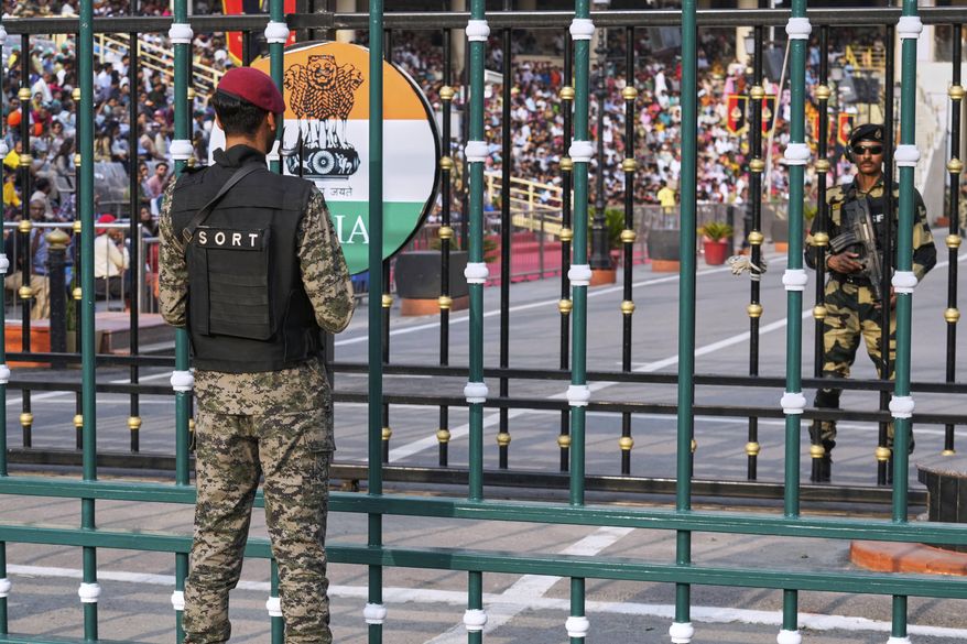 Pakistan's paramilitary soldier, left, and Indian Border Security Forces soldier, right, stand guard on their sides, during a daily closing ceremony at the Wagah, a joint post on the Pakistan and India border, near Lahore, Pakistan, Saturday, May 3, 2025. (AP Photo/K.M. Chaudary)