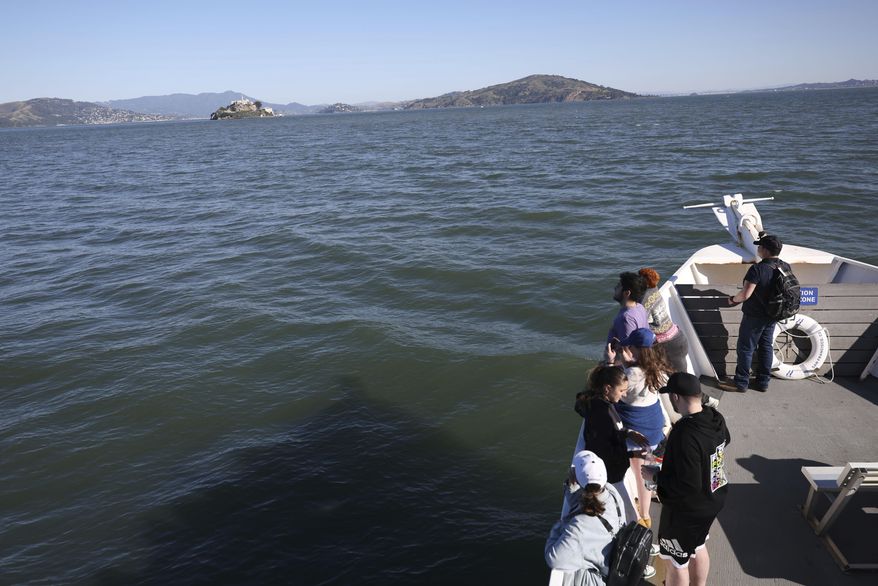 Visitors view Alcatraz Island from a tour boat Monday, May 5, 2025, in San Francisco. (AP Photo/Jed Jacobsohn)