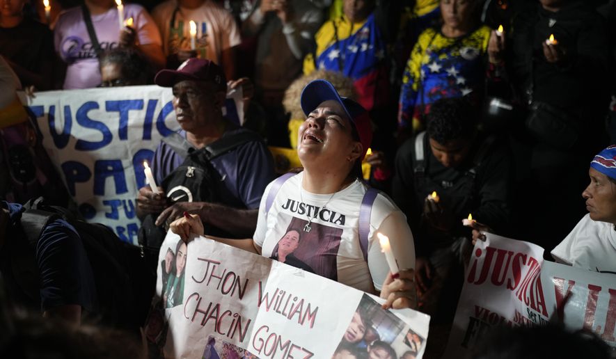 People with photos of their relatives who were deported from the U.S. to a prison in El Salvador, for being alleged members of the Tren de Aragua gang, cry and pray outside El Salvador's embassy in Caracas, Venezuela, April 2, 2025. (AP Photo/Ariana Cubillos)