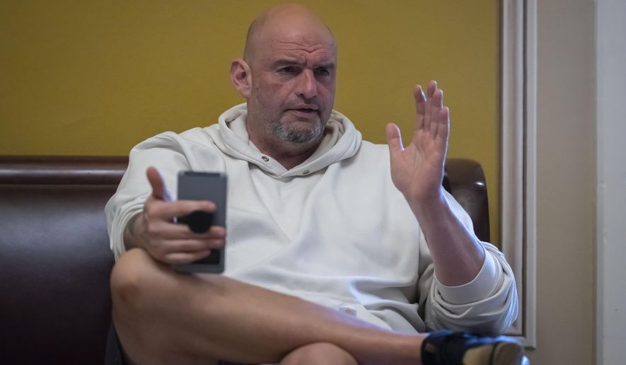 Sen. John Fetterman, D-Pa., speaks to a reporter near the Senate chamber at the Capitol in Washington, March 14, 2025. (AP Photo/Ben Curtis, File)