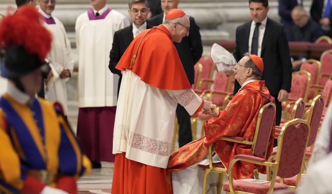 Cardinal Pietro Parolin, center, greets Cardinal Giovanni Lajolo during a final Mass celebrated by cardinals inside St. Peter's Basilica, before the conclave to elect a new pope, at the Vatican, Wednesday, May 7, 2025. (AP Photo/Gregorio Borgia)
