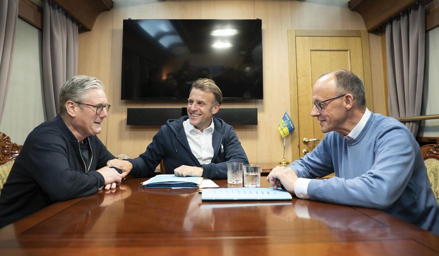 Britain's Prime Minister Keir Starmer, left, meets with French President Emanuel Macron, center, and German Chancellor Friedrich Merz onboard a train to the Ukrainian capital Kyiv where all three will hold meetings with Ukrainian President Volodymyr Zelenskyy Friday, May 9, 2025. (Stefan Rousseau/Pool Photo via AP)