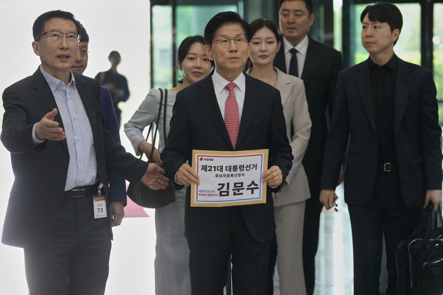 South Korea's People Power Party's presidential election candidate Kim Moon-soo, center, arrives to submit documents to register as a candidate to run in the June 3 presidential election, at the National Election Commission, Gwacheon, South Korea, Sunday, May 11, 2025. The letter read "The 21st Presidential election candidate registration application, Kim Moon-soo." (AP Photo/Ahn Young-joon)