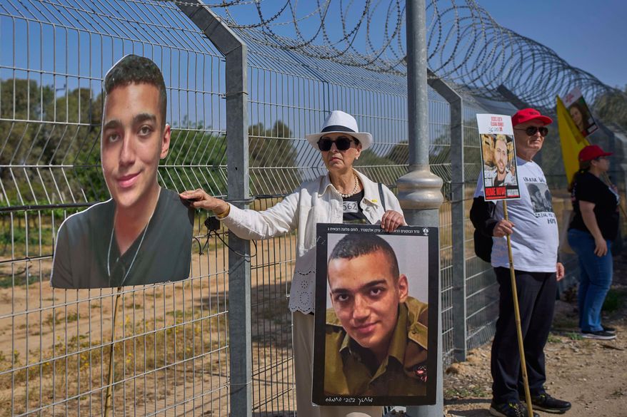 Varda Ben Baruch holds a picture of her grandson Edan Alexander, who is held hostage in Gaza, gathers with other families to call out on loudspeakers in hopes that their loved ones will hear them, near the Gaza border in Kibbutz Nir Oz, southern Israel, April 20, 2025. (AP Photo/Ohad Zwigenberg, File)