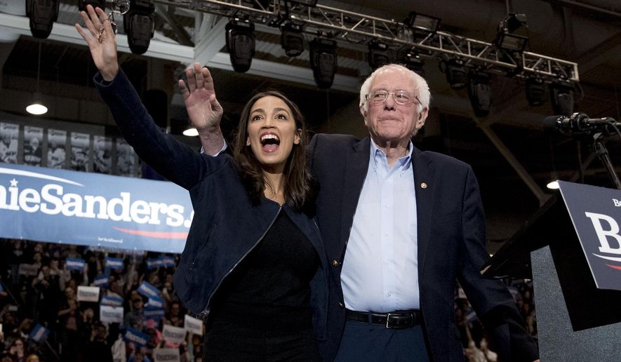 FILE - Democratic presidential candidate Sen. Bernie Sanders, I-Vt., accompanied by Rep. Alexandria Ocasio-Cortez, D-N.Y., left, takes the stage at campaign stop at the Whittemore Center Arena at the University of New Hampshire, Feb. 10, 2020, in Durham, N.H. (AP Photo/Andrew Harnik, File)
