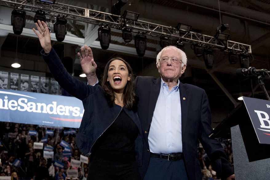FILE - Democratic presidential candidate Sen. Bernie Sanders, I-Vt., accompanied by Rep. Alexandria Ocasio-Cortez, D-N.Y., left, takes the stage at campaign stop at the Whittemore Center Arena at the University of New Hampshire, Feb. 10, 2020, in Durham, N.H. (AP Photo/Andrew Harnik, File)