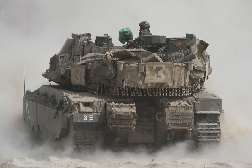 Israeli soldiers move tanks around staging area near the border with the Gaza Strip, in southern Israel, Sunday, May 18, 2025. (AP Photo/Ariel Schalit)
