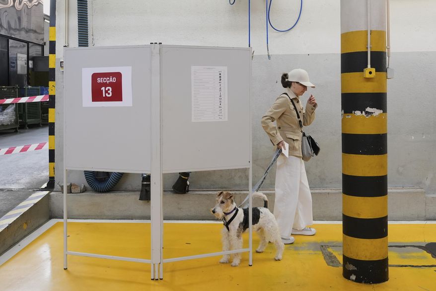 A voter holds her ballot during voting in Portugal's general election at a polling station in Lisbon, Sunday, May 18, 2025. (AP Photo/Ana Brigida)