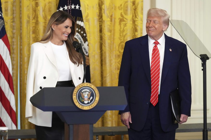 President Donald Trump, right, watches as first lady Melania Trump speaks at an event for Military Mothers, Thursday, May 8, 2025, in the East Room of the White House in Washington. (AP Photo/Jacquelyn Martin)