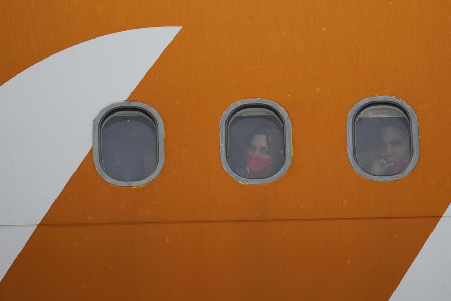 Venezuelan migrants deported from the United States look out from plane portholes upon landing at the Simon Bolivar International Airport in Maiquetia, Venezuela, Friday, May 2, 2025. (AP Photo/Ariana Cubillos) ** FILE **