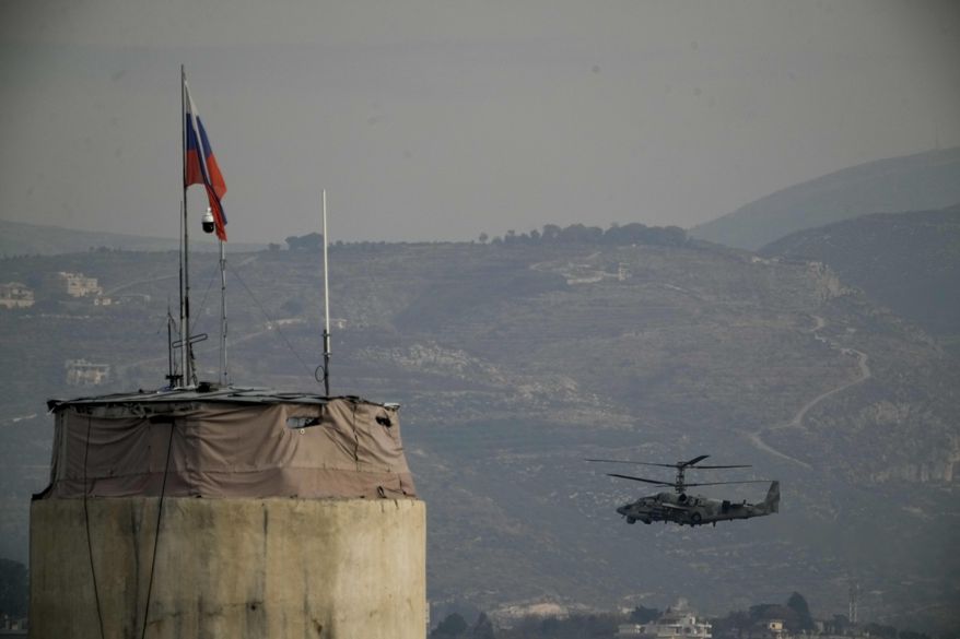 A Russian helicopter flies over the Hmeimim Air Base, a Syrian airbase currently operated by Russia, located southeast of the city of Latakia in the town of Hmeimim, Syria, on Monday, Dec.16, 2024. (AP Photo/Leo Correa, File)