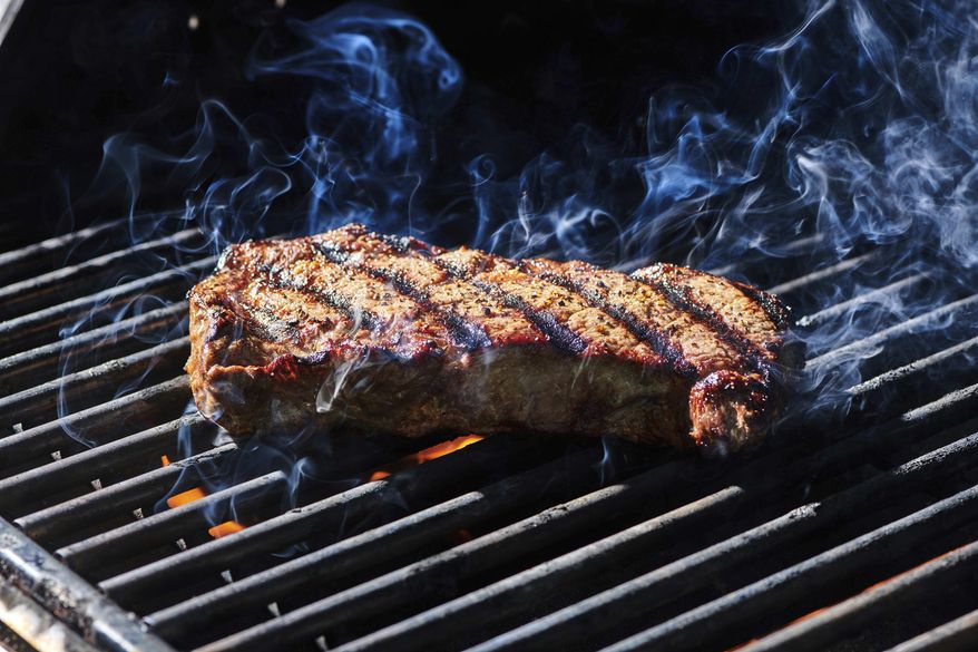 This July 2022, image provided by Cheyenne Cohen shows a ribeye steak on a grill in New Milford, Conn. (Cheyenne Cohen via AP)