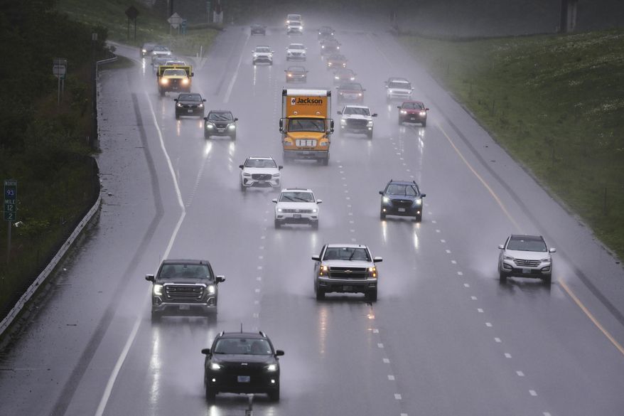 As rain from a nor'easter falls on the pavement, vehicles roll north on Route 93 during the start of the Memorial Day holiday travel, Thursday, May 22, 2025, in Londonderry, N.H. (AP Photo/Charles Krupa)