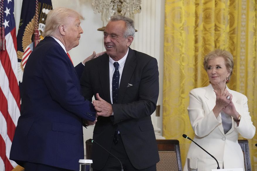President Donald Trump, Health, from left, shakes hands with Human Services Secretary Robert F. Kennedy Jr. as Education Secretary Linda McMahon looks on at the conclusion of a Make America Healthy Again (MAHA) Commission Event in the East Room of the White House, Thursday, May 22, 2025, in Washington. (AP Photo/Jacquelyn Martin)