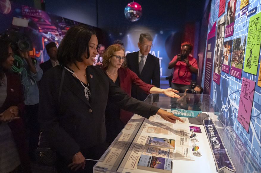 District of Columbia Mayor Muriel Bowser, from left, tours the exhibit "LGBTJews in the Federal City" with Beatrice Gurwitz, executive director of the Capital Jewish Museum and Board President Chris Wolf ahead of the museum's reopening following the killing of two Israeli Embassy staff members, Thursday, May 29, 2025, in Washington. (AP Photo/Mark Schiefelbein)