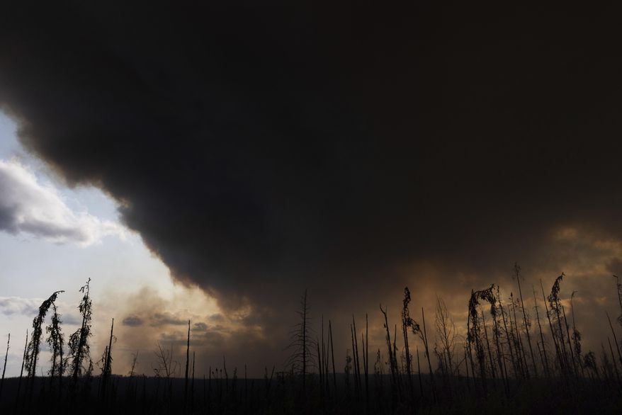 Wildfire smoke hangs in the air above Highway 97 north of Buckinghorse River, British Columbia, on Friday, May 30, 2025. (Nasuna Stuart-Ulin/The Canadian Press via AP)