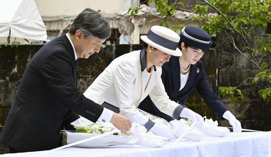 From left, Japan's Emperor Naruhito, Empress Masako and their daughter Princess Aiko lay flowers in front of "kozakura-no-to," a monument to commemorate about 1,500 people, including hundreds of school children, killed in a U.S. torpedo attack on their evacuation ship Tsushima Maru in August 1944, in Naha, Okinawa prefecture, southern Japan Thursday, June 5, 2025. (Japan Pool/Kyodo News via AP)