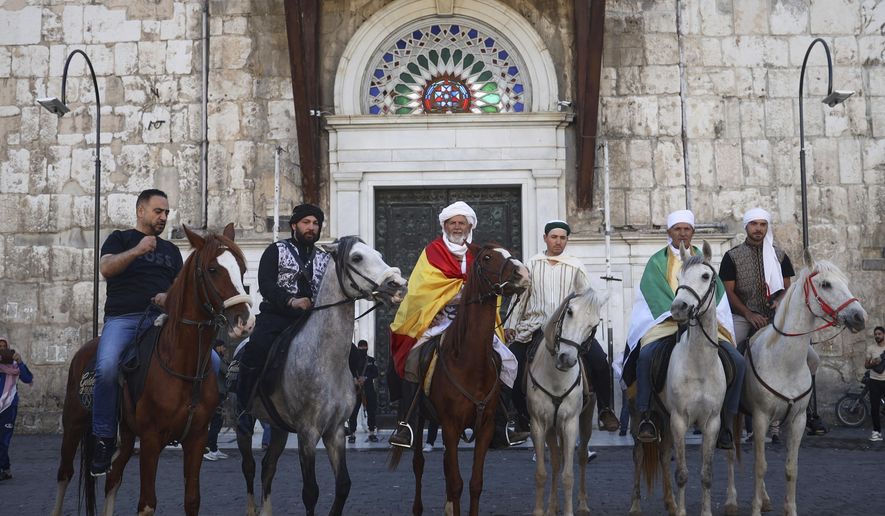 Pilgrims, including three from Spain, pose with their horses outside the Souq al-Hamidiyah market during their months-long horseback journey from Spain to Saudi Arabia to perform the Hajj, in Damascus, Syria, April 21, 2025. (AP Photo/Omar Albam)