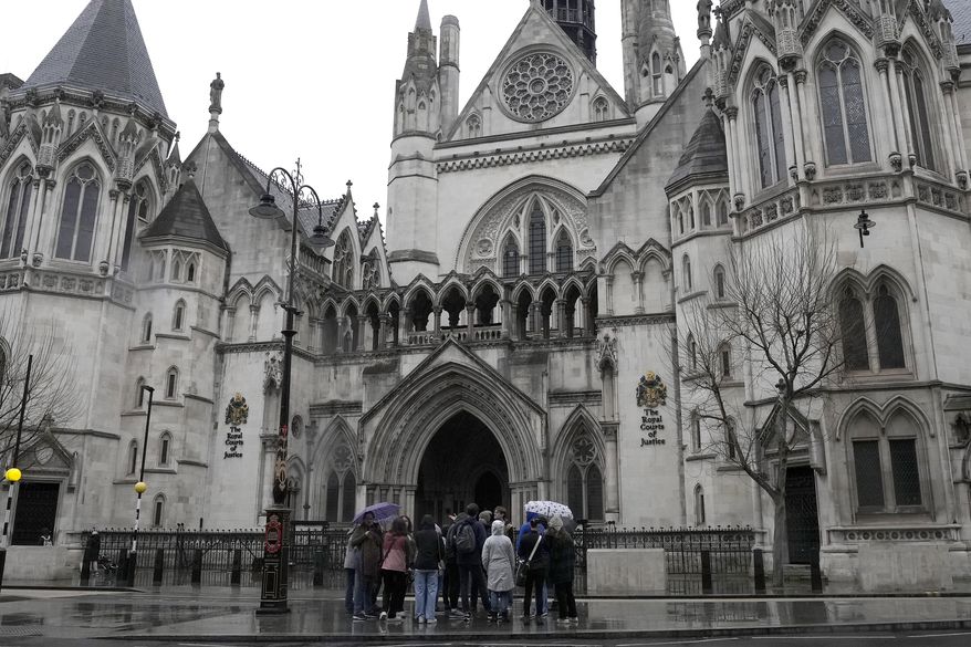 People stand outside the Royal Court of Justice in London, Friday, March 17, 2023. (AP Photo/Frank Augstein, File)