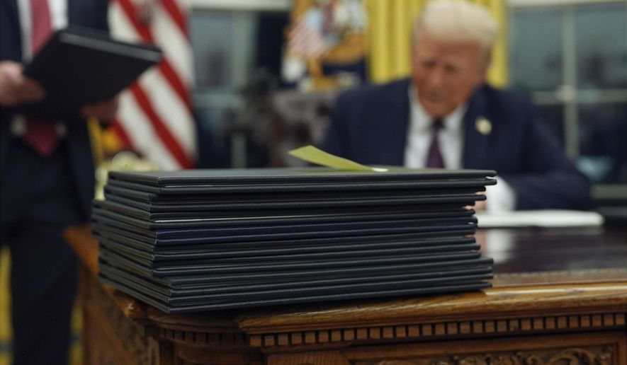 FILE - President Donald Trump signs executive orders in the Oval Office of the White House, Jan. 20, 2025, in Washington. (AP Photo/Evan Vucci, File)