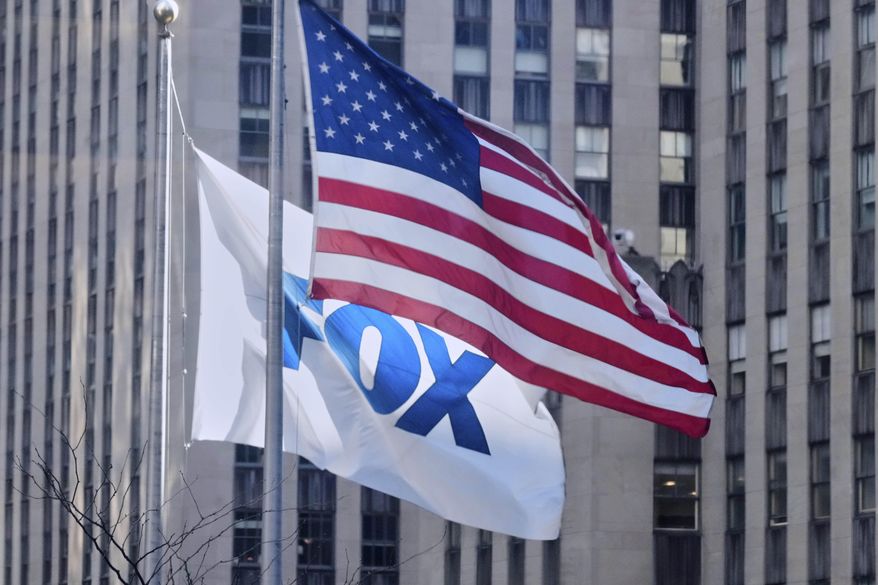 An American flag and a Fox flag fly outside Fox headquarters in New York, April 9, 2025. (AP Photo/Richard Drew, File)