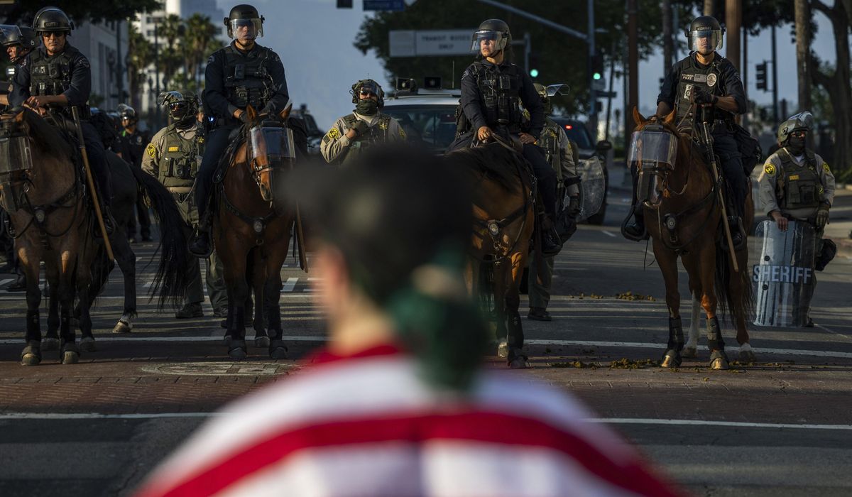 NextImg:Marines are seen standing guard at a federal building in Los Angeles