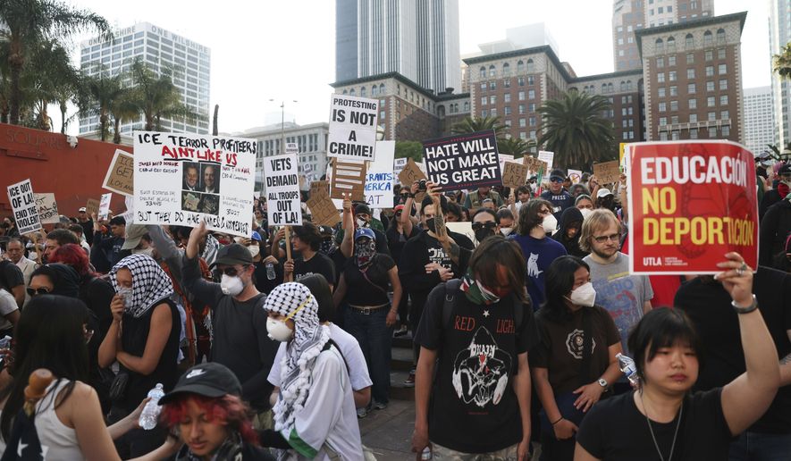 Attendees listen to a speaker during a protest at Pershing Square, Wednesday, June 11, 2025, in Los Angeles. (AP Photo/Ethan Swope)