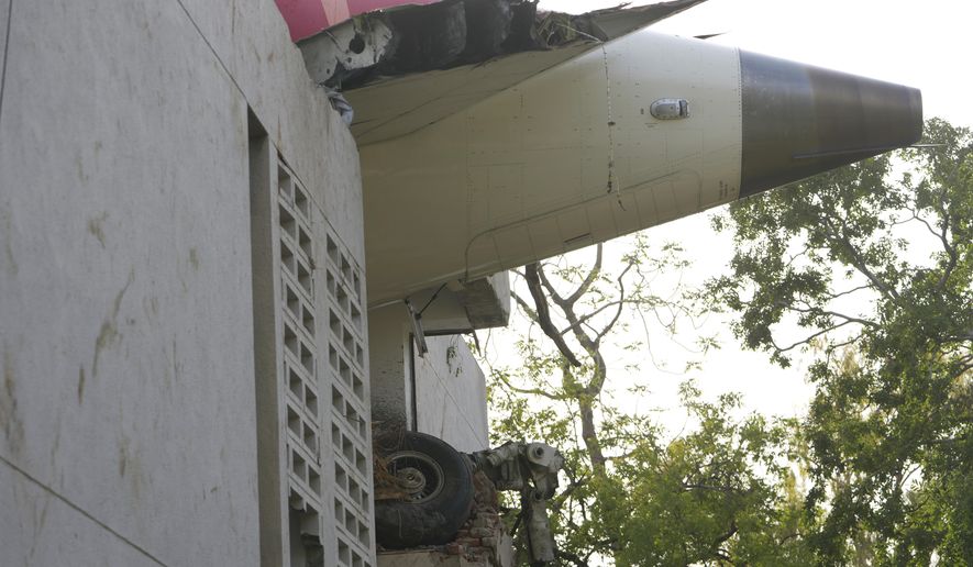 The debris of an airplane sticks out of a building after it crashed in India's northwestern city of Ahmedabad in Gujarat state, Thursday, June 12, 2025. (AP Photo/Ajit Solanki)