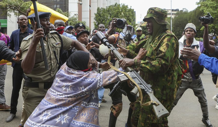 A protester scuffles with a police officer during a protest over the death in police custody of blogger Albert Ojwang, in Nairobi, Kenya, Thursday, June 12, 2025. (AP Photo/Andrew Kasuku)