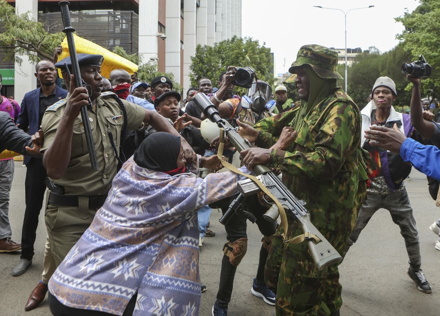A protester scuffles with a police officer during a protest over the death in police custody of blogger Albert Ojwang, in Nairobi, Kenya, Thursday, June 12, 2025. (AP Photo/Andrew Kasuku)