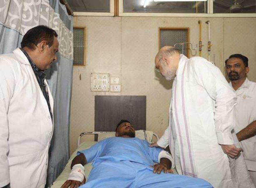 This handout photo issued by the Indian Ministry of Home Affairs shows Home Affairs Minister Amit Shah meeting British plane crash survivor Vishwash Kumar Ramesh, 40, at a hospital in Ahmedabad, after Air India confirmed Mr Ramesh was the sole survivor of the 242 people on board the London-bound Boeing 787 Dreamliner when it crashed into a medical college shortly after take-off from Ahmedabad airport. (Ministry of Home Affairs India via AP)