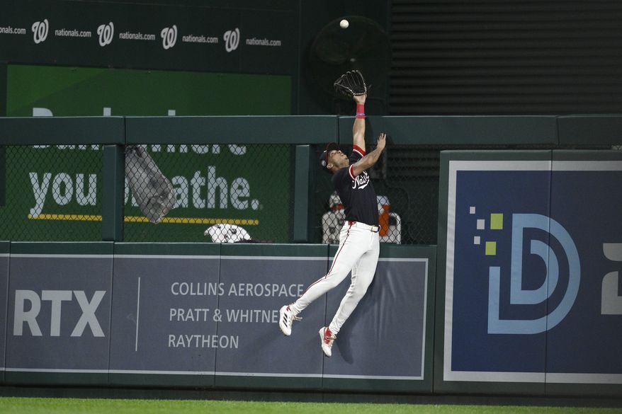 Washington Nationals right fielder Daylen Lile reaches for a two-run home run by Colorado Rockies' Mickey Moniak during the ninth inning of a baseball game, Monday, June 16, 2025, in Washington. (AP Photo/Nick Wass)