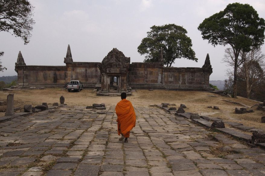FILE- A Cambodian Buddhist monk walks toward the Cambodia's 11th century Hindu Preah Vihear temple, which was enlisted as UNESCO's World Heritage site in Preah Vihear province, about 245 kilometers (152 miles) north of Phnom Penh, Cambodia Tuesday, Feb. 8, 2011. (AP Photo/Heng Sinith, File)
