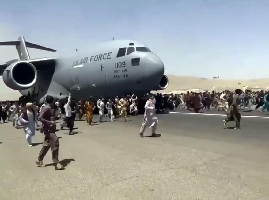 Hundreds of people desperate to escape Afghanistan run alongside a U.S. Air Force plane as it moves down a runway of the international airport in Kabul, Monday, Aug.16. 2021. (AP Photo, File)