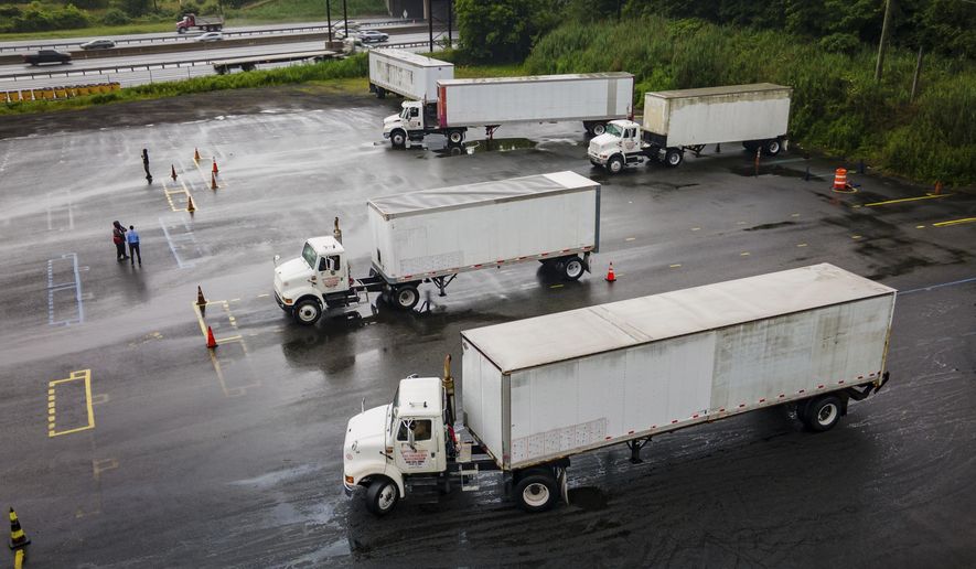 Trucking students practice reverse parking in training trucks at the Driving Academy on Thursday, Sept. 14, 2017 in Linden, N.J., where students prepare to obtain a Commercial Driver’s License (CDL) with multilingual instructors. (AP Photo/Angelina Katsanis)