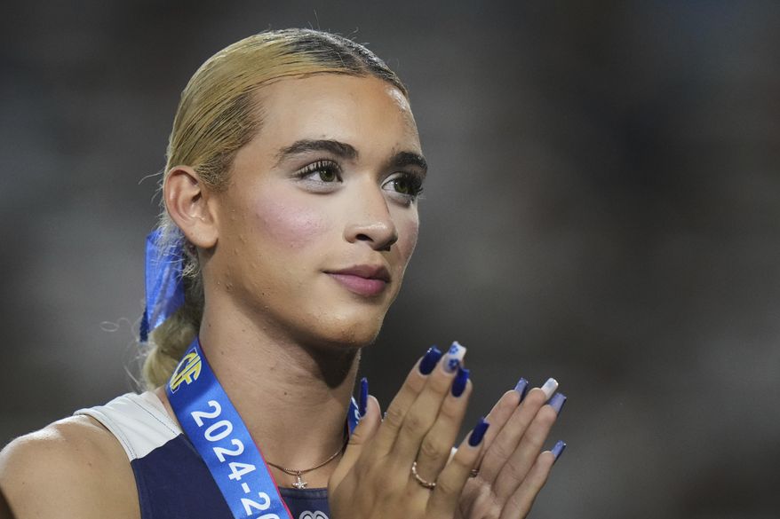 AB Hernandez, a transgender student at Jurupa Valley High School, stands on the podium during a medal ceremony for the triple jump at the California high school track-and-field championships in Clovis, Calif., May 31, 2025. (AP Photo/Jae C. Hong, file)