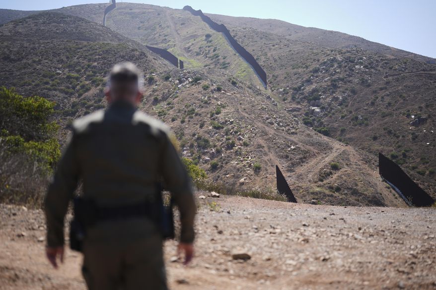 Border Patrol Agent Rood looks out to a gap in the two border walls separating Mexico and the United States, Tuesday, June 10, 2025, in San Diego. (AP Photo/Gregory Bull)