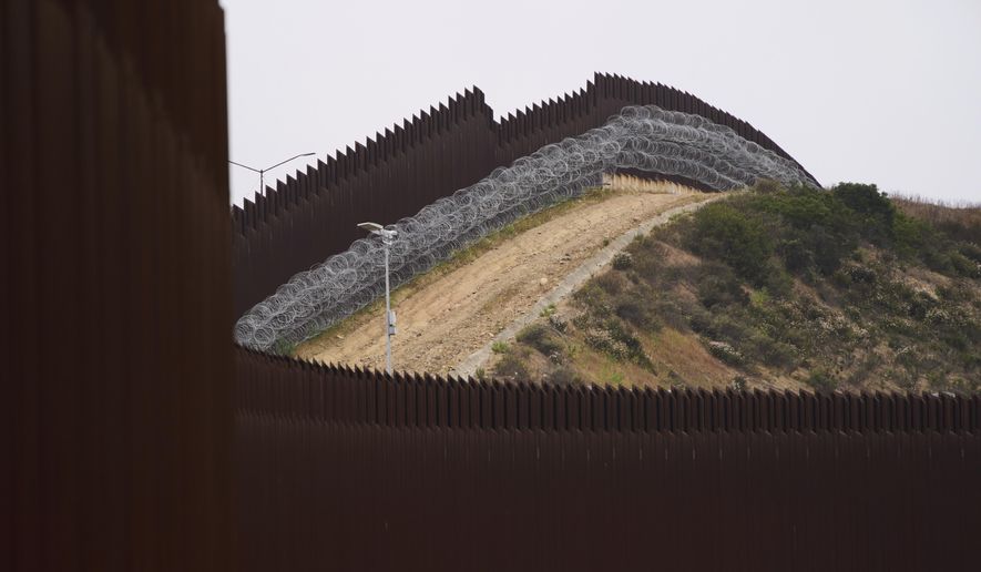 Concertina wire lines the interior of a border wall, one of two separating Tijuana, Mexico, from the United States, June 4, 2025, in San Diego. (AP Photo/Gregory Bull, File)