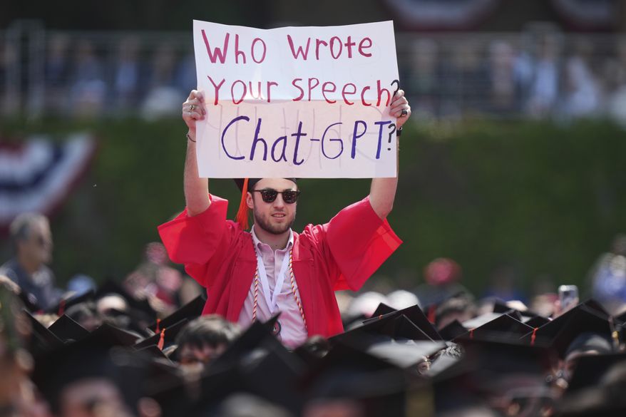 FILE - A person in a graduation cap and gown holds a sign during an address by David Zaslav, president and CEO of Warner Bros. Discovery, at Boston University commencement ceremonies, May 21, 2023, in Boston. (AP Photo/Steven Senne, file)