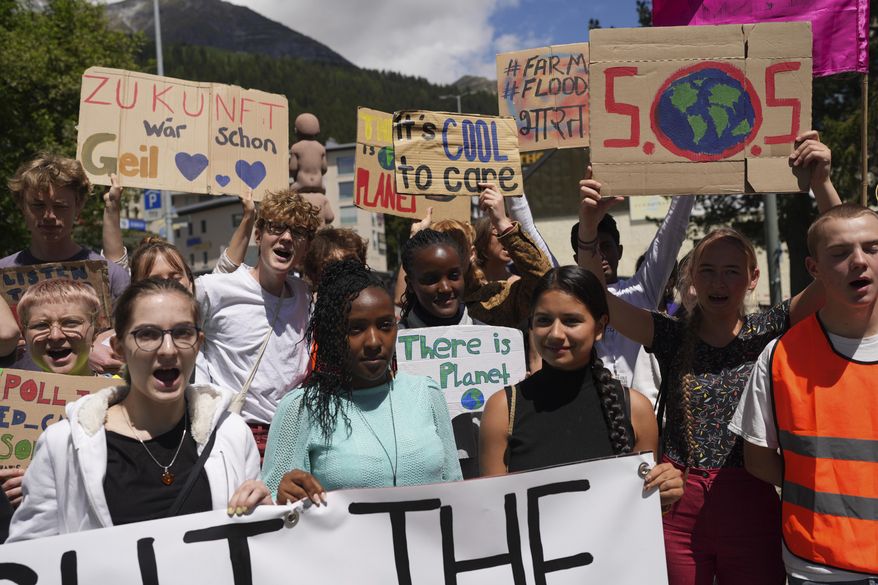 FILE - Climate activists Elizabeth Wathuti, of Kenya, Vanessa Nakate, of Uganda, and Helena Gualinga of Ecuador attend the climate protest alongside the World Economic Forum in Davos, Switzerland, on May 26, 2022. (AP Photo/Evgeniy Maloletka, File)
