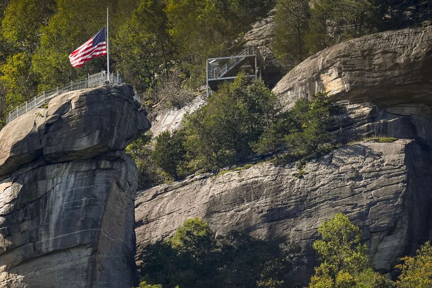 A U.S. flag flies half-staff on top of Chimney Rock mountain in the aftermath of Hurricane Helene, Oct. 2, 2024, in Chimney Rock Village, N.C. (AP Photo/Mike Stewart, File)