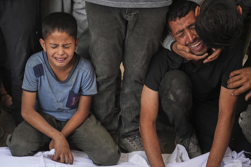 Relatives react as they mourn over the body of a loved one killed, along with others, in Israeli strikes on the Gaza Strip, at Al-Shifa Hospital in Gaza City, Saturday, June 28, 2025. (AP Photo/Jehad Alshrafi)