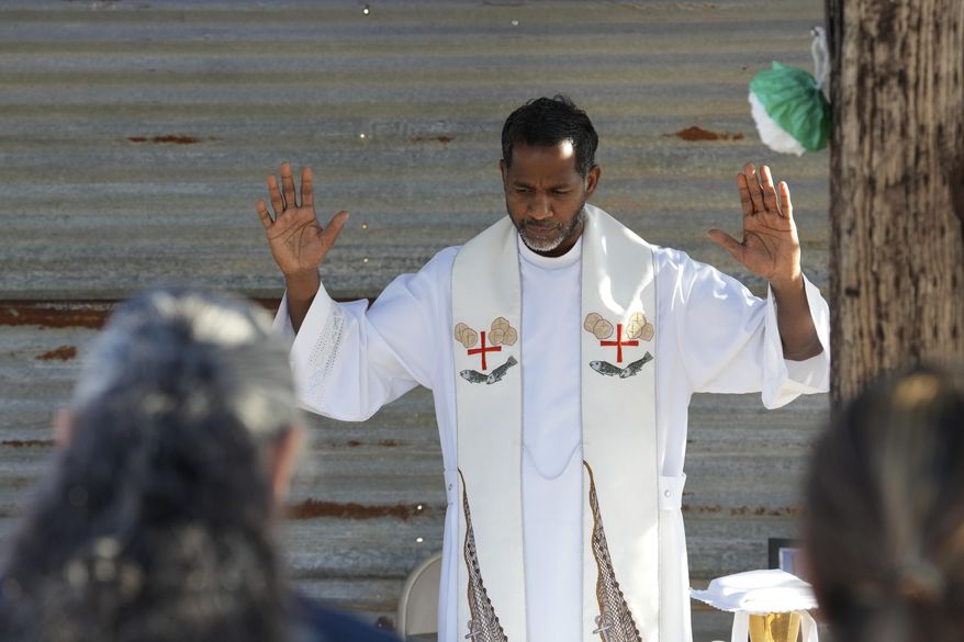 The Rev. Aro Varnabas starts the St. John the Baptist's feast day Mass in Saguaro National Park near Tucson, Ariz., on Tuesday, June 24, 2025. (AP Photo/Ross D. Franklin)